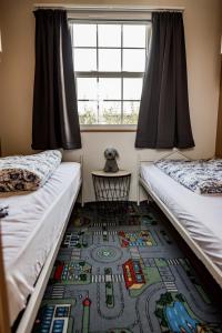 um quarto com duas camas, uma janela e um tapete em Chalet Zeeuws Genieten in Baarland, Zeeland em Baarland