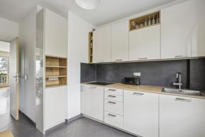 a kitchen with white cabinets and a sink at Le Saint-Cloud Chic in Saint-Cloud
