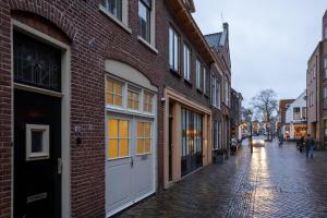 a cobblestone street in an old city with buildings at Drive-in appartement centrum Alkmaar in Alkmaar