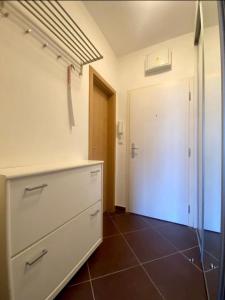 a kitchen with a white dresser and a door at Private apartment 1km from center in Nivy