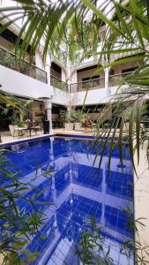 una gran piscina con una palmera frente a un edificio en Riad Soir De Marrakech, en Marrakech