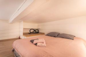 ein Schlafzimmer mit einem Bett mit einer rosa Decke in der Unterkunft Studio Cardeurs in Aix-en-Provence