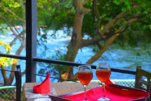 Sunwin River Cabana في اوداوالاوي: كأسين من النبيذ الأحمر يجلسون على الطاولة