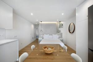 Dormitorio blanco con cama y mesa en Luxury Loft Mar y Sol 1 en Tacoronte