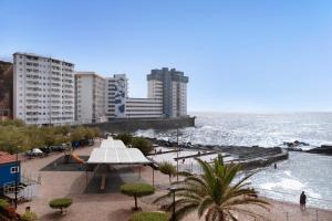 una pista de tenis en una playa con edificios y el océano en Luxury Loft Mar y Sol 1 en Tacoronte