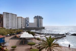 un campo da tennis su una spiaggia con edifici e l'oceano di Luxury Loft Mar y Sol 1 a Tacoronte
