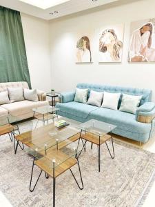 sala de estar con sofá azul y mesas en شقة جميلة بغرفتين نوم ودخول ذاتي ١١ en Riad