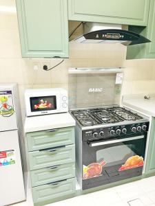 a kitchen with a stove and a microwave at شقة جميلة بغرفتين نوم ودخول ذاتي ١١ in Riyadh