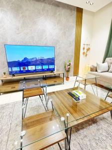 sala de estar con TV de pantalla plana grande en شقة جميلة بغرفتين نوم ودخول ذاتي ١١, en Riad
