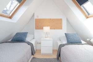 two beds in a attic bedroom with blue pillows at Fischerhus in Timmendorfer Strand