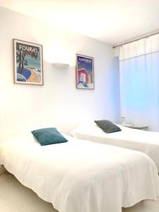 two beds in a room with white sheets at MAISON CENTRE VILLE AVEC JARDIN , TERRASSE, et GARAGE VELOS in La Rochelle
