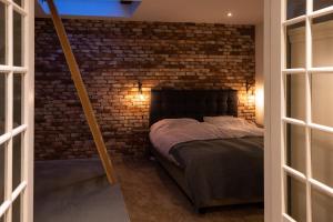 a bedroom with a brick wall and a bed at Drive-in appartement centrum Alkmaar in Alkmaar
