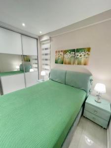 een slaapkamer met een groen bed en een schilderij aan de muur bij Alimos Luxury Prestige in Athene