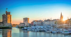 a group of boats docked in a marina at sunset at MAISON CENTRE VILLE AVEC JARDIN , TERRASSE, et GARAGE VELOS in La Rochelle