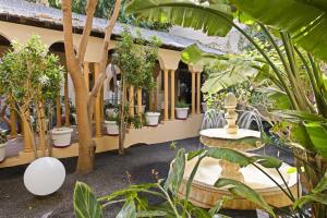 
a patio area with tables, chairs, and umbrellas at Elba Lucía Sport & Suite Hotel in Costa de Antigua
