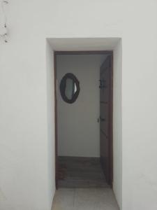 a hallway with a door and areath on a wall at CASA CARMELA in Higuera de la Sierra
