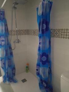 um chuveiro com uma cortina de chuveiro azul na casa de banho em CASA CARMELA em Higuera de la Sierra