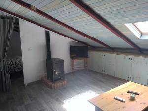 a living room with a stove and a tv at CASA CARMELA in Higuera de la Sierra