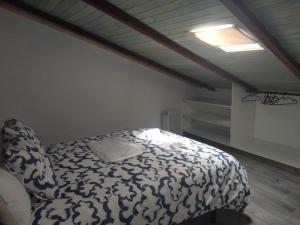 a bedroom with a bed with a white and black blanket at CASA CARMELA in Higuera de la Sierra