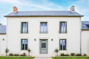 Casa blanca con ventanas negras y puerta gris en Les Olympiades - Magnifique Villa d'évasion, en Vendeuvre-du-Poitou