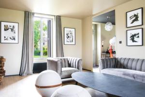 ein Wohnzimmer mit einem Sofa, Stühlen und einem Tisch in der Unterkunft Les Olympiades - Magnifique Villa d'évasion in Vendeuvre-du-Poitou