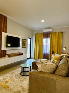 a living room with a couch and a flat screen tv at d’Pinx Nest in Gaborone