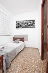 1 dormitorio con 1 cama y una pintura en la pared en Acogedor apartamento valencia 3 dormitorios, en Aldaia