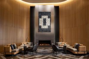 un vestíbulo con mesas, sillas y chimenea en Park Hyatt Toronto, en Toronto