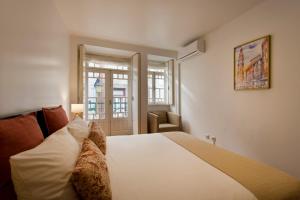 a bedroom with a large white bed and a window at Home @ Porto Clérigos Apartment in Porto
