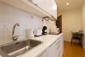 a kitchen with a stainless steel sink and appliances at Home @ Porto Clérigos Apartment in Porto