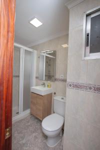 y baño con aseo blanco y lavamanos. en Acogedor apartamento valencia 3 dormitorios, en Aldaia