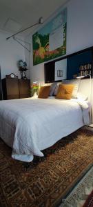 a bedroom with a large white bed with a rug at Jardin secreto en el centro de Barcelona 2 in Barcelona
