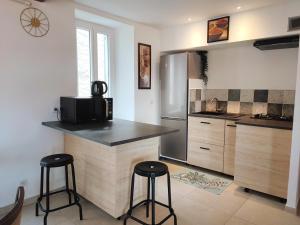 a kitchen with a counter and two bar stools at BOHO location 1 in Bonnieux