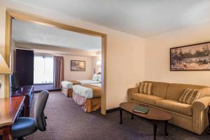 Quality Inn & Suites Albany Airport في لاثام: غرفة في الفندق مع أريكة وسرير