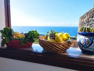 duas cestas de fruta num peitoril de janela com o oceano em RADYSHAMS DAMMUSI LE PALME & BAIT em Pantelleria