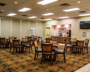 a dining room with tables and chairs and a bar at Quality Inn & Suites Mansfield in Mansfield