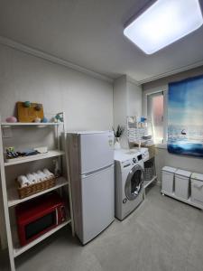 a laundry room with a refrigerator and a washing machine at You Here,Stay - 5min to Hapjeong Station, 10mins to Hongdae in Seoul