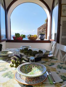 uma mesa com pratos e tigelas de comida em RADYSHAMS DAMMUSI LE PALME & BAIT em Pantelleria