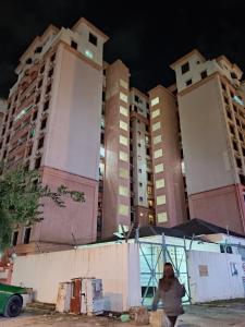 a woman walks in front of tall buildings at Maricel homestay in Kota Kinabalu