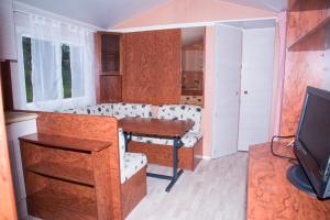 ein Wohnzimmer mit einem Tisch und einem TV in der Unterkunft Camping Nature et insolite proche Disneyland in Saâcy-sur-Marne