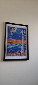 a framed painting of a lighthouse on a wall at Athenian Asty Guesthouse in Athens