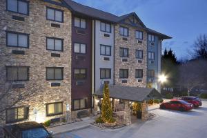 un gran edificio de ladrillo con luces de Navidad en un aparcamiento en Brookstone Lodge near Biltmore Village, Ascend Hotel Collection, en Asheville