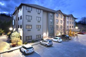 een groot gebouw met auto's geparkeerd op een parkeerplaats bij Brookstone Lodge near Biltmore Village, Ascend Hotel Collection in Asheville