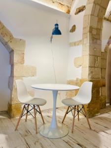 a table with three chairs and a blue lamp at La Bitta Suite in Brindisi