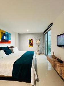 a bedroom with a large bed and a flat screen tv at Morros Vitri California in Cartagena de Indias