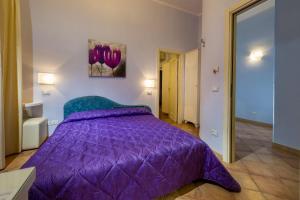 um quarto com uma cama roxa e um edredão roxo em Badia Rooms & Breakfast em Castellammare del Golfo