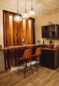 - une cuisine avec un bar avec deux chaises et des lumières dans l'établissement Aslyra, à Liège