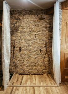 Aslyra في لييج: غرفة بحائط من الطوب ومقعدين للاستحمام