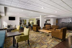 un vestíbulo con sillas y mesas y una sala de espera en Comfort Inn en Cadillac