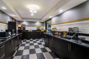 a large kitchen with black cabinets and a checkered floor at Comfort Inn in Cadillac